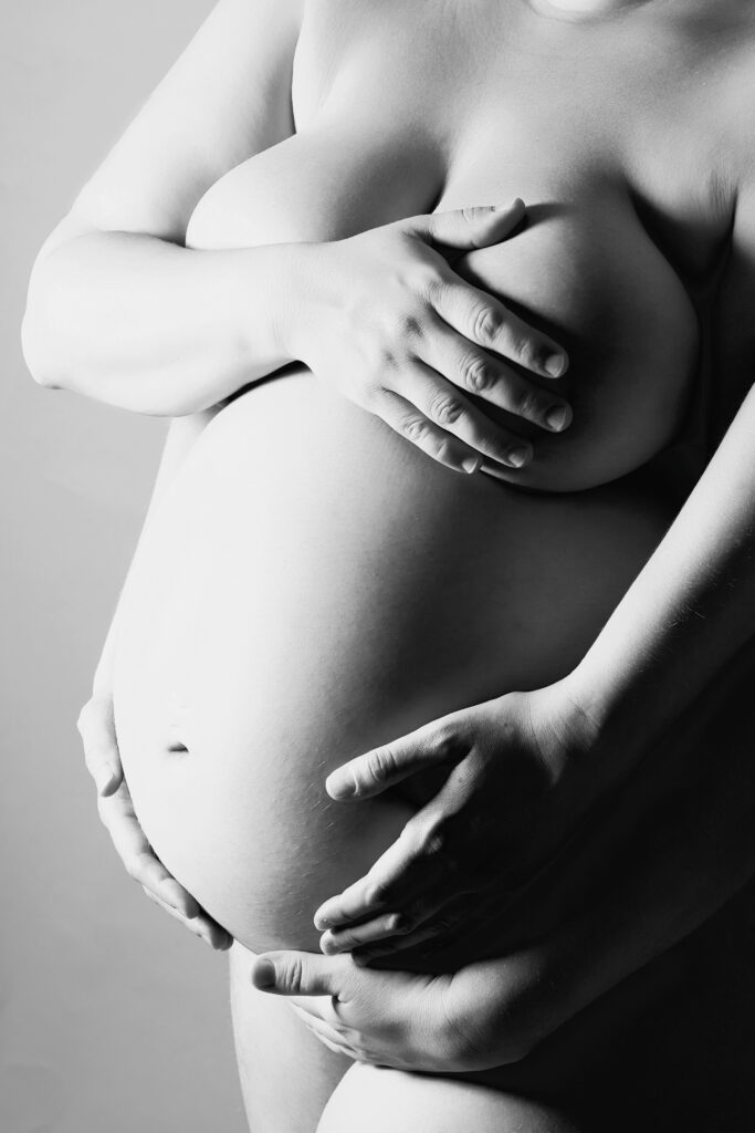 Närbild på gravidmage med händer