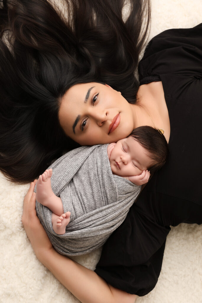 Mamma håller om sovande nyfödd bebis