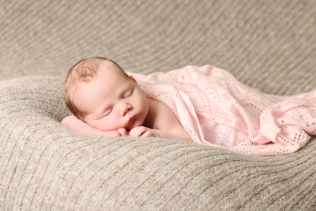 Sovande nyfödd bebis inlindad i filt