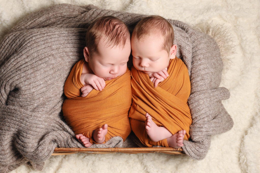 Två nyfödda tvillingar inlindade i filt