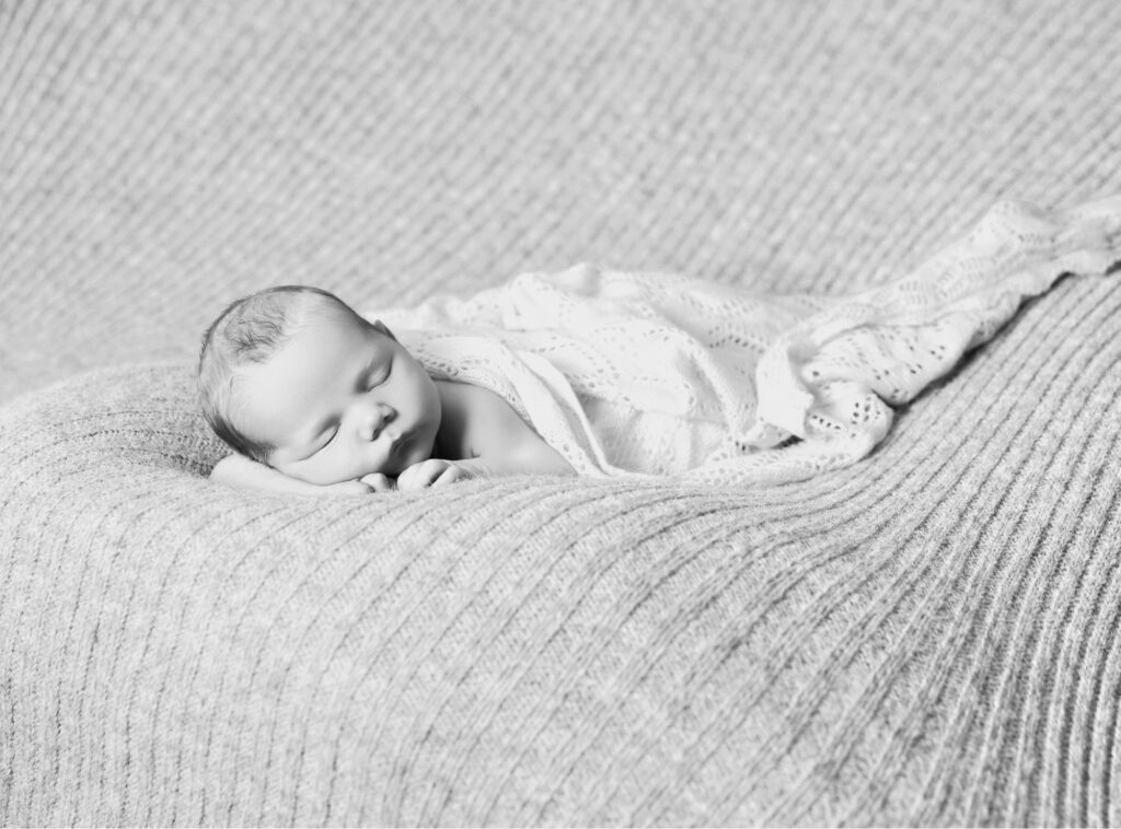 Sovande nyfödd bebis på beige filt
