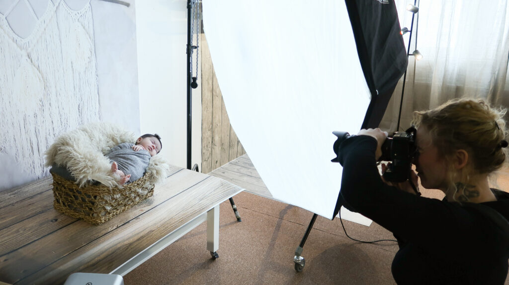 Fotograf fotograferar nyfödd bebis i studio